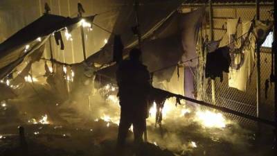 Un hombre observa las llamas que devoran unas tiendas de campaña. Foto EFE.