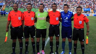 Los capitanes de Olimpia, Donis Escober, y Motagua, Júnior Izaguirre, posando junto a la cuarteta arbitral en los actos protocolares.