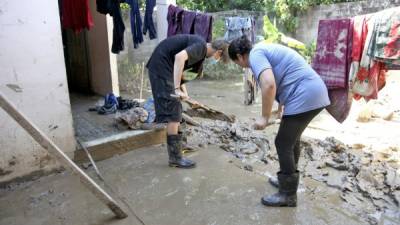 Cientos de familias sacan incontables carretadas de lodo de sus viviendas.El sistema de agua potable está funcionando en la Céleo, pero en muchas casas la llave está abierta y se está derramando. Fotos: Franklyn Muñoz