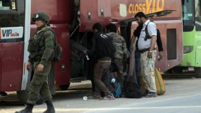 Un soldado ruso observa junto a uno de los autobuses del Gobierno que permanecen parqueados a las afueras de Erbin en la zona rural de Damasco, Siria. EFE/YOUSSEF BADAWI/Archivo