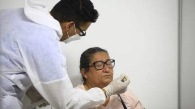 Un microbiólogo hace un hisopado a una paciente en el triaje de Expocentro. Foto: Moisés Valenzuela.