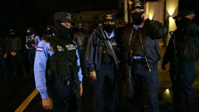 Autoridades policiales esperan en las afueras de la casa del expresidente Juan Orlando Hernández para ejecutra la orden de arresto en su contra.