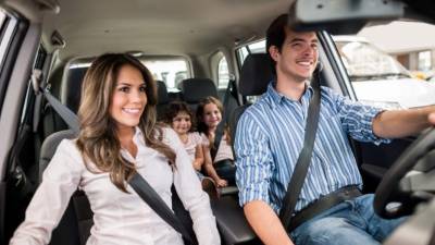 portrait of mother and little daughter driving in car together