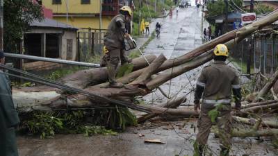 Diferentes trabajadores del Estado despejan una calle de los destrozos que dejó el paso del huracán Julia, en la ciudad de Bluefields (Nicaragua).