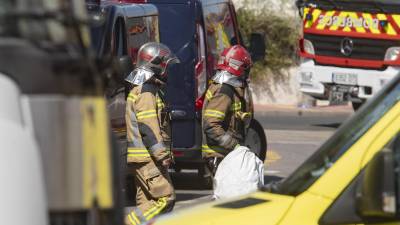 Dos bomberos durante las labores de rescate de los cuerpos de los fallecido en el incendio.