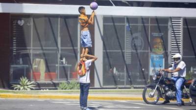 Dos niños hacen malabares bajo un semáforo hoy martes 12 de junio de 2018 en Tegucigalpa (Honduras). EFE