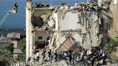 Miembros de los servicios de rescate buscan hoy entre los escombros de un edificio derrumbado en Torre Annunziata, cerca de Nápoles, Italia.EFE