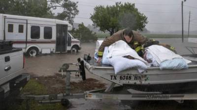 A Lumberton firefighter holds on to two nursing home patients as a member of the Cajun Navy drives his truck during the evacuation of a nursing home due to rising flood waters in Lumberton, North Carolina, on September 15, 2018 in the wake of Hurricane Florence. Besides federal and state emergency crews, rescuers were being helped by volunteers from the 'Cajun Navy' -- civilians equipped with light boats, canoes and air mattresses -- who also turned up in Houston during Hurricane Harvey to carry out water rescues. / AFP PHOTO / Alex Edelman