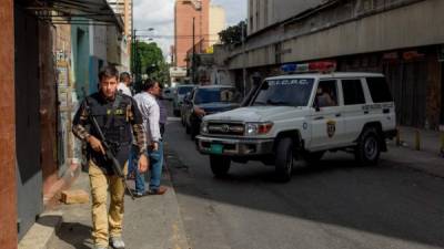 Policías venezolanos resguardan el edificio donde ocurrió el tiroteo que causó la muerte de cinco personas.