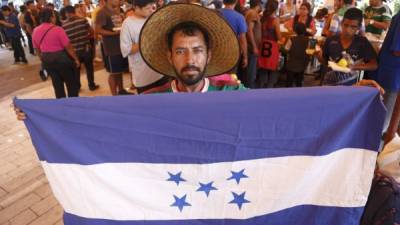 En la imagen, un migrante centroamericano posa con una bandera de Honduras durante su parada en la iglesia de la Asunción, en el estado de Puebla (México). EFE/Francisco Guasco
