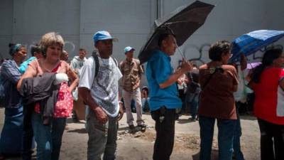 Un grupo de gente hace cola para comprar comida en el popular distrito de Catia, en Caracas. EFE