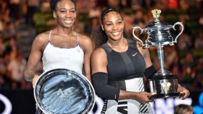 Serena y Venus Williams posando con sus respectivos trofeos del Abierto de Australia. Foto AFP