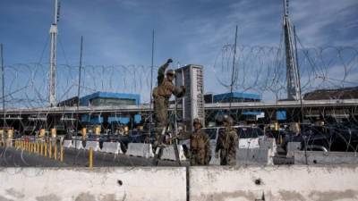 US Department of Defence personnel install barriers requested by Custom and Border Protection at the San Ysidro port of entry, San Diego, US, under the Operation Secure Line anticipating the arrival of Central American migrants heading towards the border, as seen from the Mexican side of the border in Tijuana, Mexico, on November 13, 2018. - US Defence Secretary Jim Mattis said Tuesday he will visit the US-Mexico border, where thousands of active-duty soldiers have been deployed to help border police prepare for the arrival of a 'caravan' of migrants. (Photo by GUILLERMO ARIAS / AFP)