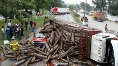 El tráfico se paralizó por varias horas en la carretera hacia Villanueva. El carro rojo quedó debajo de la carga de madera.