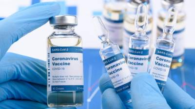 Coronavirus COVID-19 single dose small vials and multi dose in scientist hands concept. Research for new novel corona virus immunization drug.