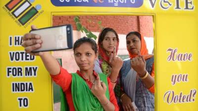 Los votantes indios posan para una foto mientras muestran su dedo marcado con tinta después de emitir su voto en un centro de votación en las afueras de Amritsar. (Foto de NARINDER NANU / AFP)