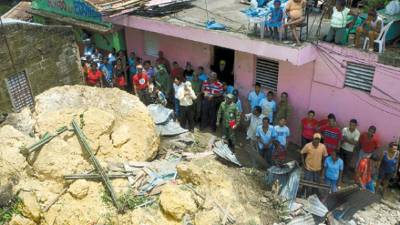 Residents look at several houses destroyed by a landslide in Guachupita, Santo Domingo, Wednesday, Aug. 27, 2008. Authorities said that eight people died, including two infants, in the landslide triggered by Hurricane Gustav. (AP Photo/Ramon Espinosa)