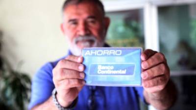 Un hondureño muestra su tarjeta de ahorros. Ayer no pudo hacer retiros.