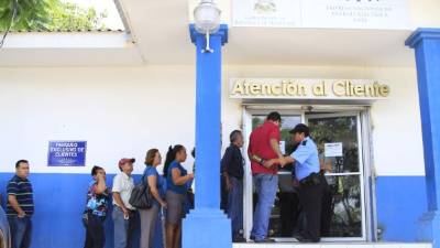 Abonados hacen fila afuera de la Enee, en La Puerta.