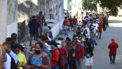 Personas migrantes de diversas nacionalidades hacen fila para tramitar papeles migratorios hoy, en la ciudad de Tapachula.