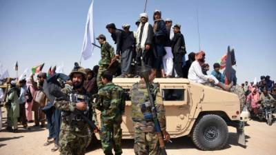 Militantes y residentes talibanes afganos se paran en un vehículo blindado Humvee del Ejército Nacional Afgano. AFP/Archivo