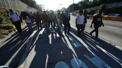 En la imagen, hoy, unos 100 salvadoreños que se disponen a inmigrar caminan hacia San Salvador (El Salvador). EFE