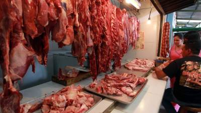 Tres clientes en una carnicería de la Feria del Agricultor y del Artesano de Tegucigalpa.