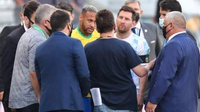 Neymar y Messi conversaron por varios minutos con funcionarios de salud y al final nadie llegó a un acuerdo por lo que el juego fue suspendido. Foto EFE.