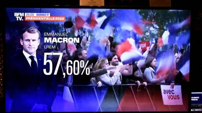 Esta fotografía tomada en París el 24 de abril de 2022 muestra una pantalla de televisión que muestra el resultado de las elecciones presidenciales de Francia del presidente francés y candidato del partido La Republique en Marche (LREM), Emmanuel Macron. (Foto de STEPHANE DE SAKUTIN / AFP)