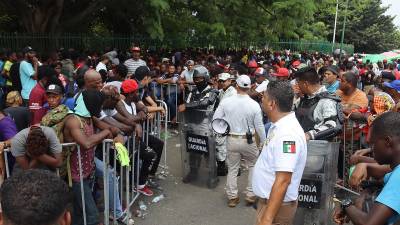 Migrantes hacen fila para tramitar papeles migratorios hoy, en Tapachula (México).