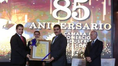 Jorge Faraj, presidente de la CCIC, entrega el galardón a Jesús Canahuati. Observan el presidente Juan Orlando Hernández y el presidente del Congreso, Mauricio Oliva.