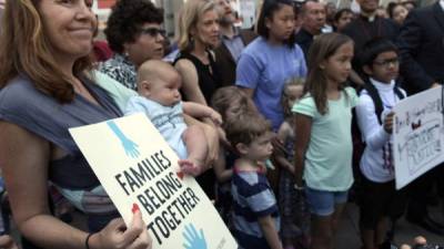 Unas madres y sus hijos gritan consignas mientras participan en una manifestación contra la separación de niños de sus padres en la frontera.