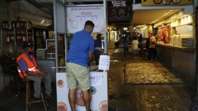 Un sampedrano se desinfecta las manos y las plantillas de sus zapatos en un punto de bioseguridad antes de entrar al mercado Dandy.