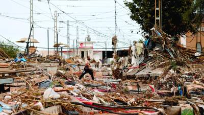 Un hombre cruza las destrozadas vías de la línea 1 del metro de Valencia en Paiporta. El panorama es desolador.