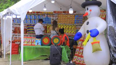 <b>Dos hondureños compran cohetes en una carpa de La Lima, Cortés. Foto: Melvin Cubas</b>