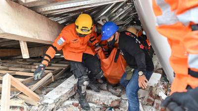 Rescatistas continúan sacando cuerpos de entre los escombros de varios edificios derribados tras el sismo.
