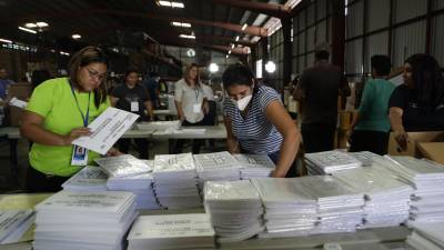 Funcionarios del Tribunal Supremo Electoral (TSE) organizan los paquetes que contienen las papeletas y los padrones electorales para los comicios del próximo 4 de febrero.