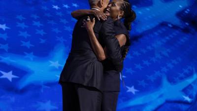 El expresidente estadounidense Barack Obama (i) abraza a la exprimera dama Michelle Obama antes de pronunciar un discurso durante la segunda noche de la Convención Nacional Demócrata.