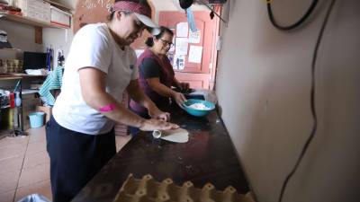 Rose Uribe amasa para crear alimentos, venderlos y agenciarse fondos para construir la escuela. Ahora, todos los sábados venderá nieves en su cafetería, ubicada junto a la Despensa Familiar.