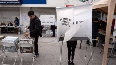 Dos personas ejercen el voto en un centro electoral de la capital mexicana.