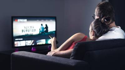 Movie stream service on smart tv. Couple watching series online. Woman choosing film or new season with remote control. Video on demand (VOD) site mockup on screen. Digital streaming network.