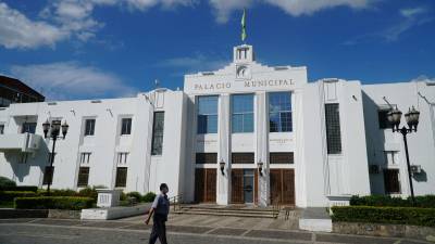 Un hombre camina frente al palacio municipal de San Pedro Sula.