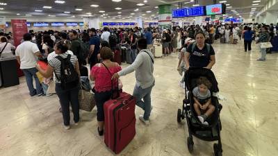 Pasajeros esperan para abordar un avión, este miércoles, en el aeropuerto de Cancún (México).