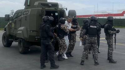 El exvicepresidente ecuatoriano Jorge Glas (C) siendo escoltado por miembros de la policía antes de su traslado a la prisión de máxima seguridad La Roca en Guayaquil, Ecuador.