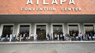 Decenas de personas hacen fila en un centro de convención para ejercer su voto en la capital panameña.