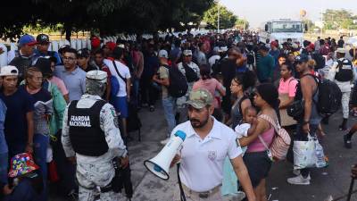 Migrantes hacen fila para tramitar documentos ante el Instituto Nacional de Migración (INM).