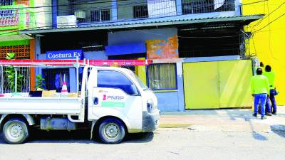 <b>Empleados del RNRP revisan un medidor de energía en una zona de San Pedro Sula.</b>