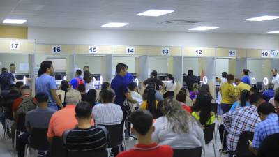 Ciudadanos hacen el trámite de sus pasaportes en oficina del INM en San Pedro Sula.