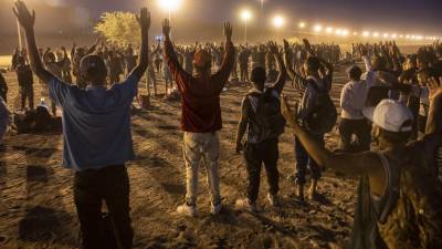 Un grupo de migrantes realiza una oración esperando ser procesados por la Patrulla Fronteriza tras haber cruzado hacia EEUU.