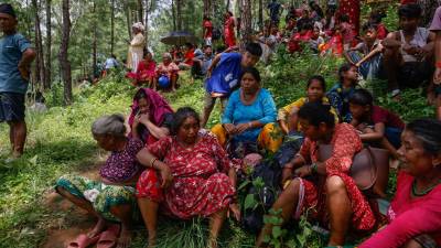 Personas se refugian en un lugar más seguro tras otra alerta de inundación repentina en el distrito de Nuwakot, Nepal, tras la masiva riada del miércoles. EFE/EPA/NARENDRA SHRESTHA